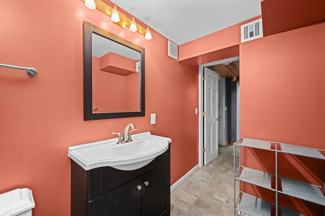 a bathroom with a sink a toilet and mirror