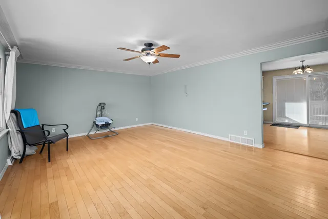 a view of a room with wooden floor and a ceiling fan