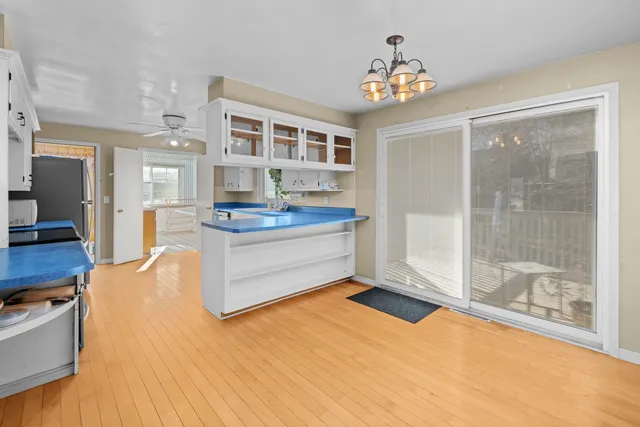a living room with kitchen island granite countertop furniture and a chandelier