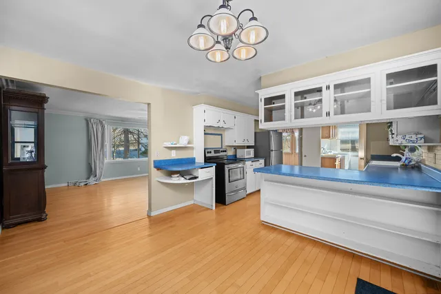a living room with stainless steel appliances granite countertop a couch and cabinets