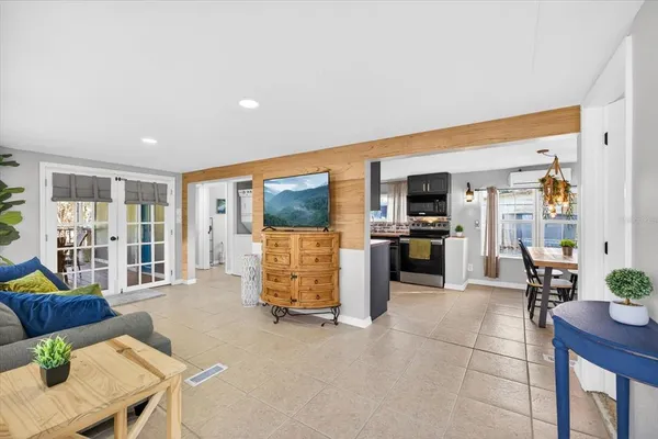 a living room with furniture a large window and kitchen view
