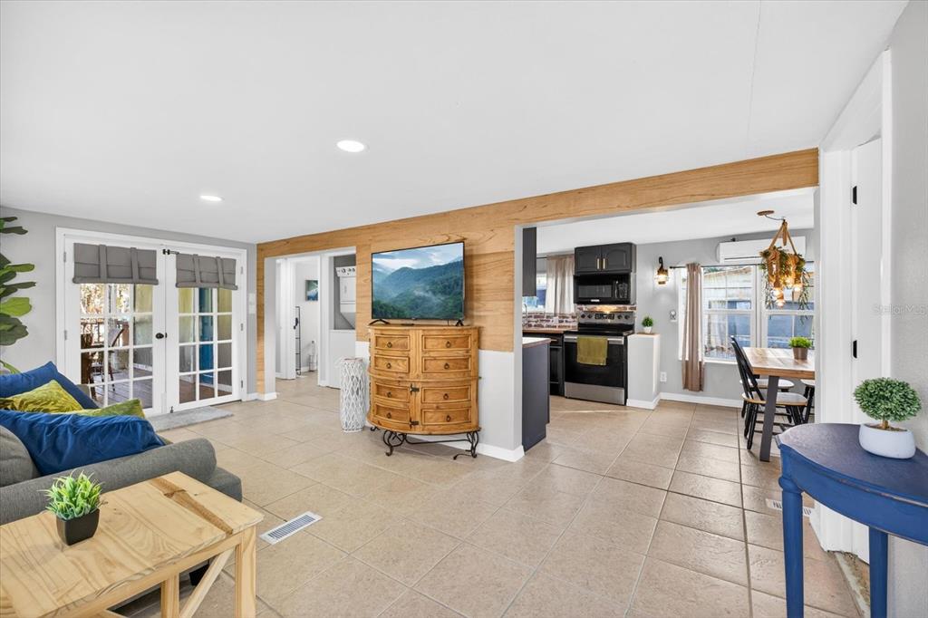 7286 Aberdeen Court Weeki Wachee, FL 34607 - Photo 8 of 37 a living room with furniture a large window and kitchen view