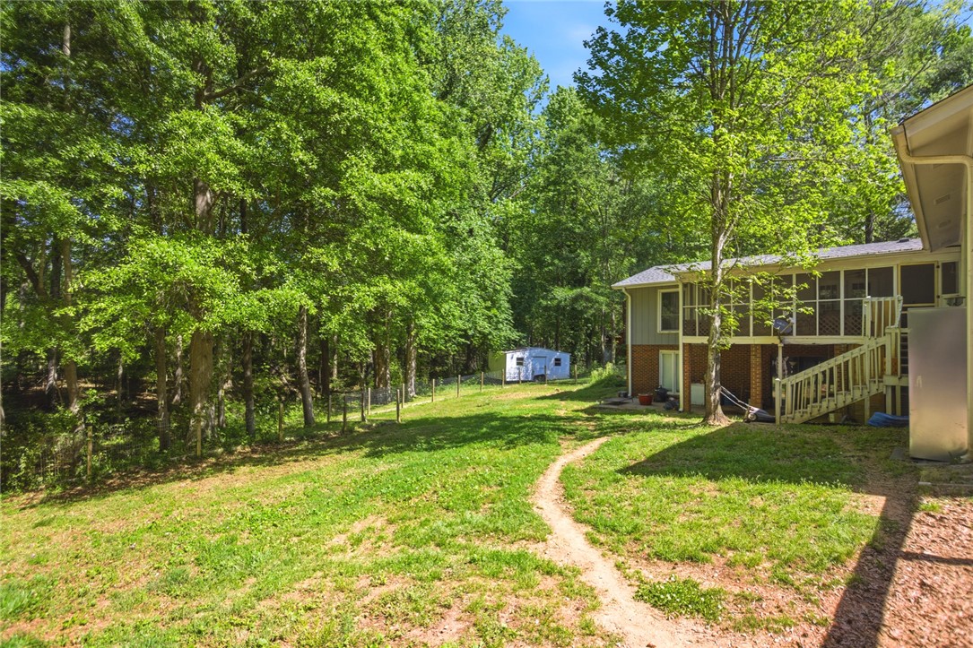 311 Cumberland Way Anderson, SC 29621 - Photo 39 of 44 A winding path leads through the verdant yard, past a serene wooded area and a secluded back deck.