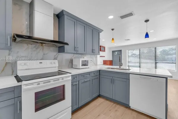 a kitchen with a stove sink and cabinets