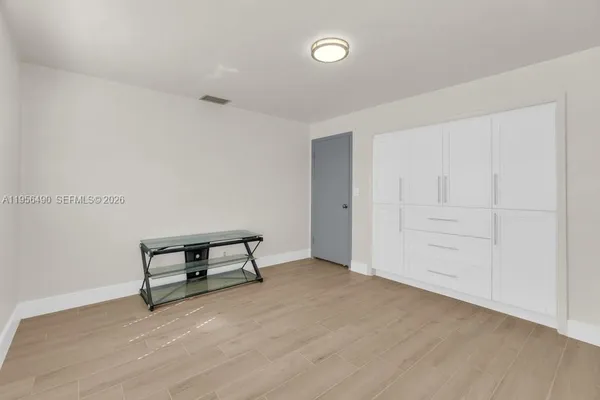 a view of an empty room with wooden floor