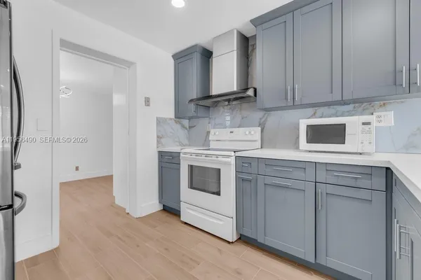 a kitchen with white cabinets and white appliances