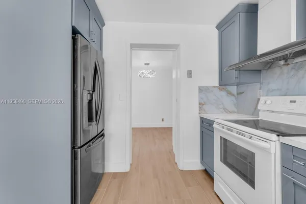 a kitchen with a stove top oven and refrigerator