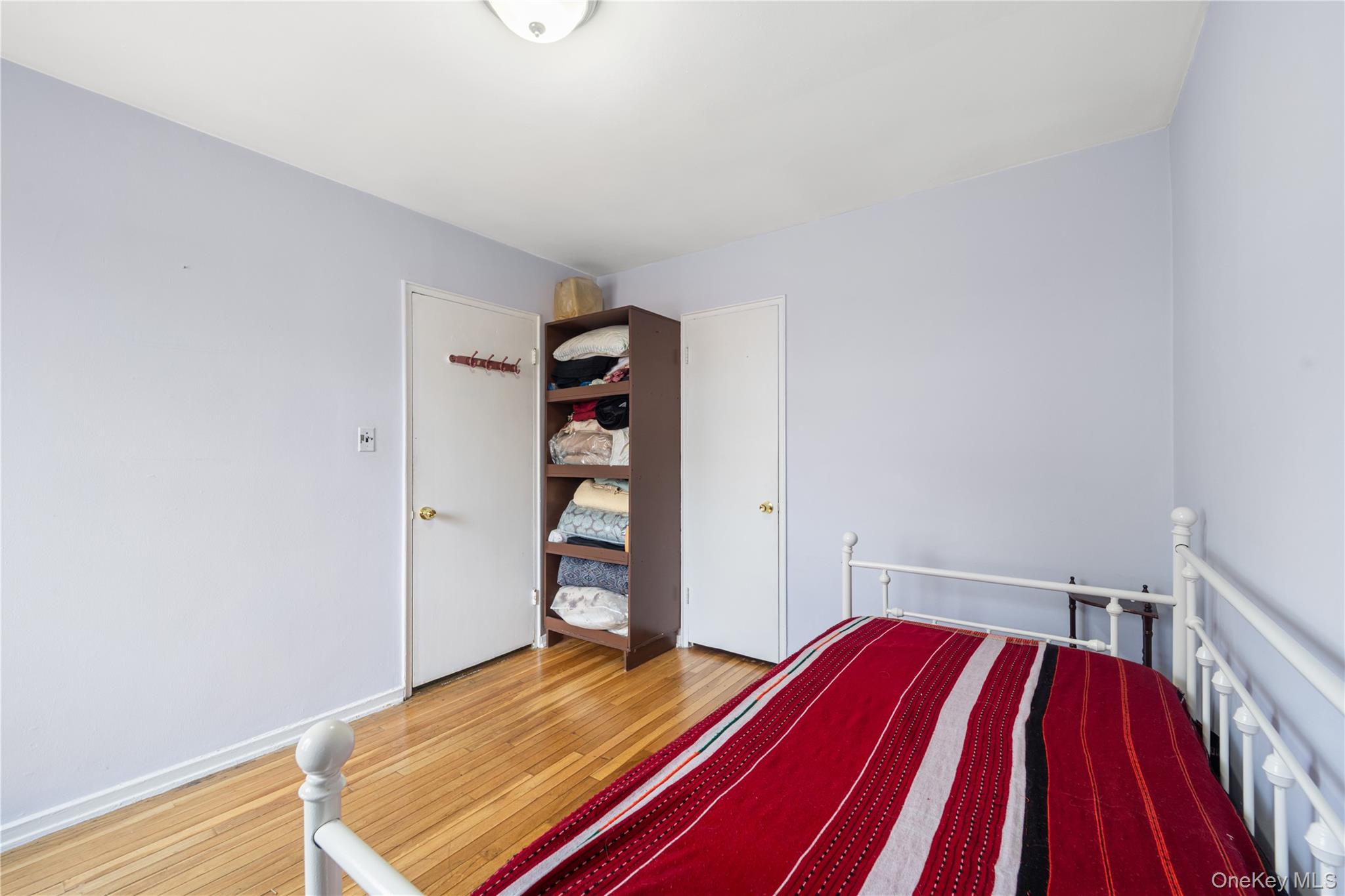 225-08 88th Avenue, Unit UPPR Queens, NY 11435 - Photo 16 of 20 a bedroom with a bed and a book shelf