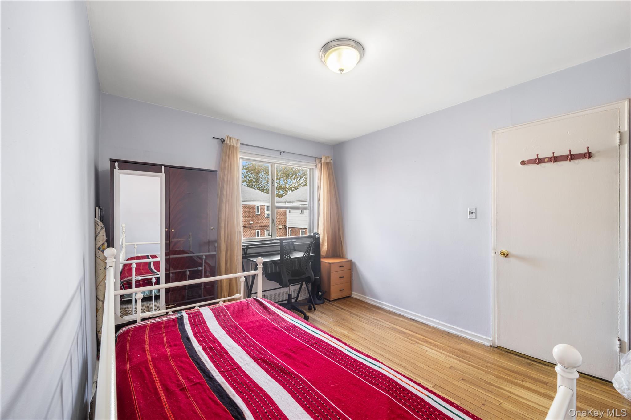 225-08 88th Avenue, Unit UPPR Queens, NY 11435 - Photo 17 of 20 a bedroom with bed and a wooden floor
