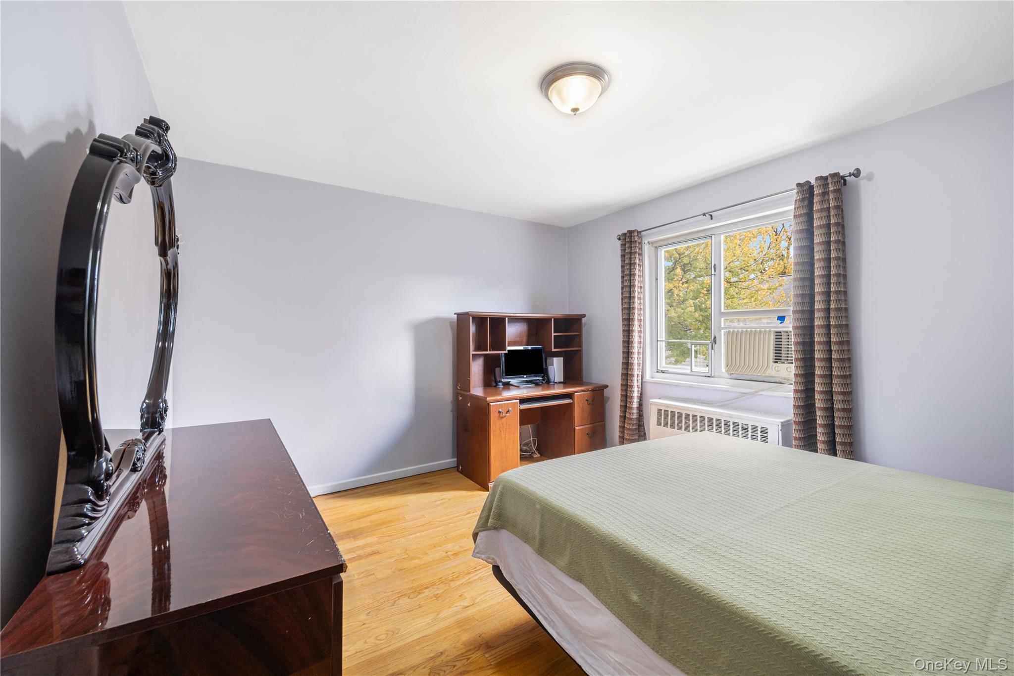 225-08 88th Avenue, Unit UPPR Queens, NY 11435 - Photo 18 of 20 a bedroom with a bed and a flat screen tv
