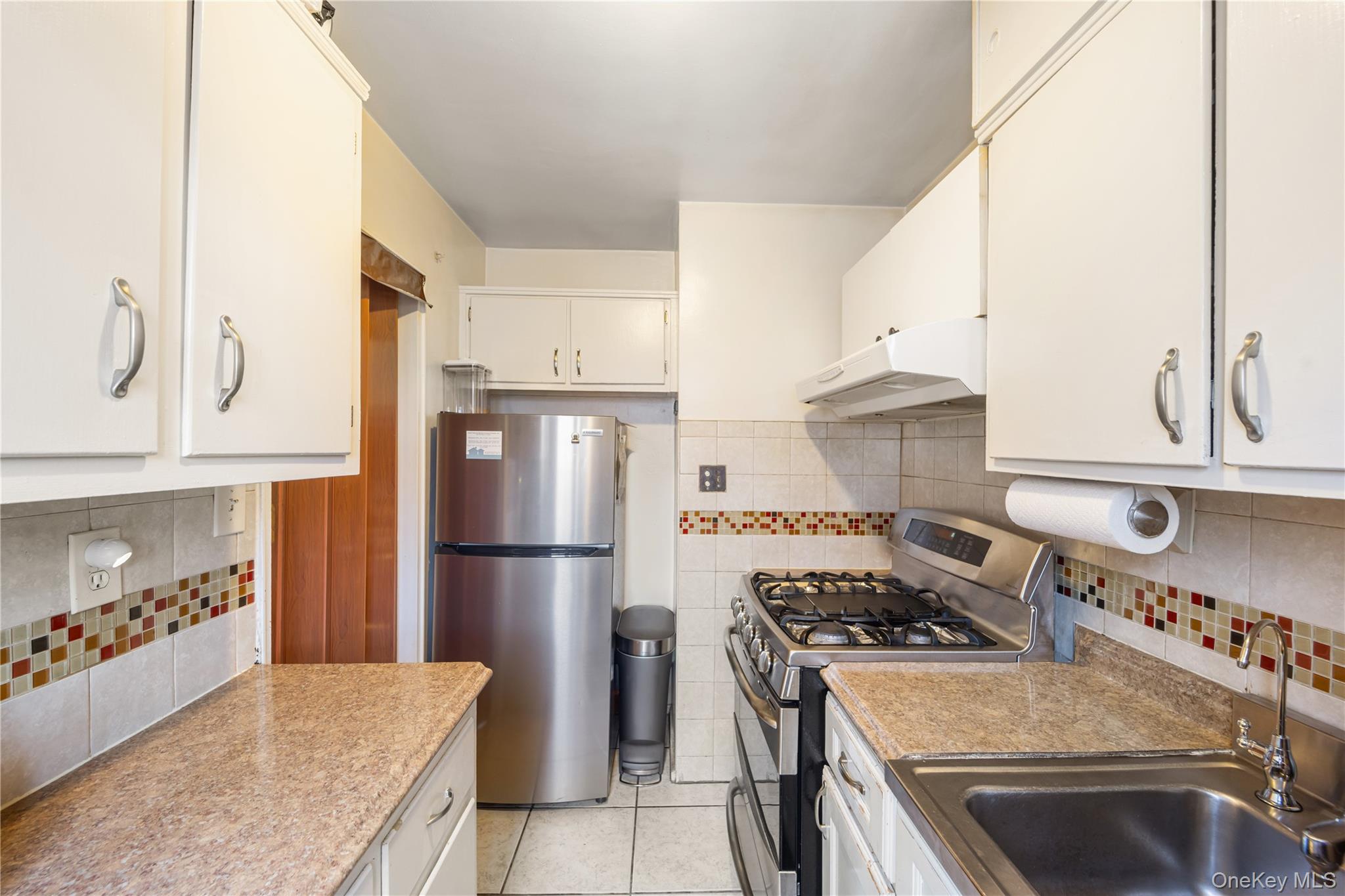 225-08 88th Avenue, Unit UPPR Queens, NY 11435 - Photo 8 of 20 a kitchen with a stove and a refrigerator