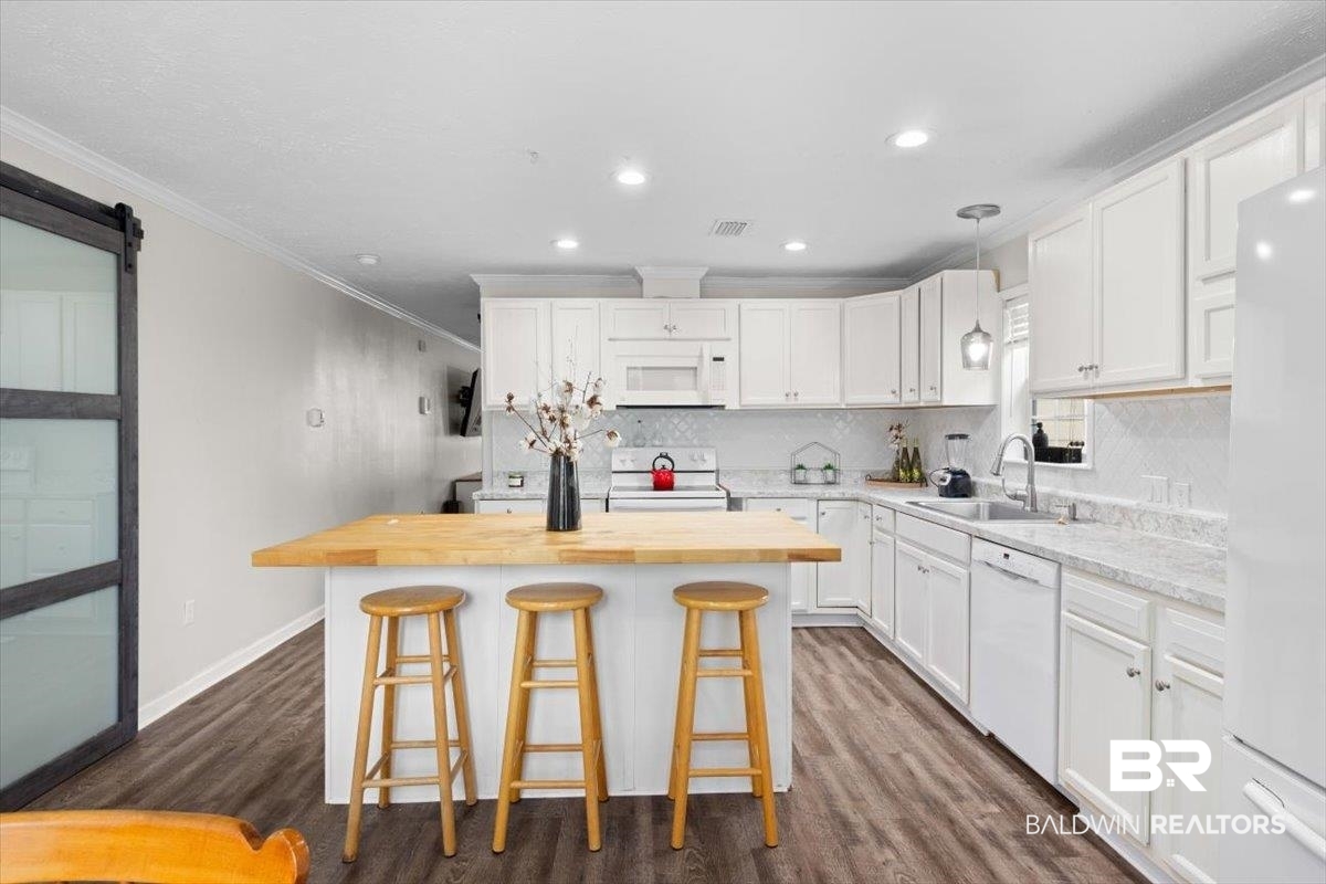 6971 March Road Theodore, AL 36582 - Photo 9 of 26 Kitchen with white cabinets, white appliances, ornamental molding, butcher block counters, and a sink