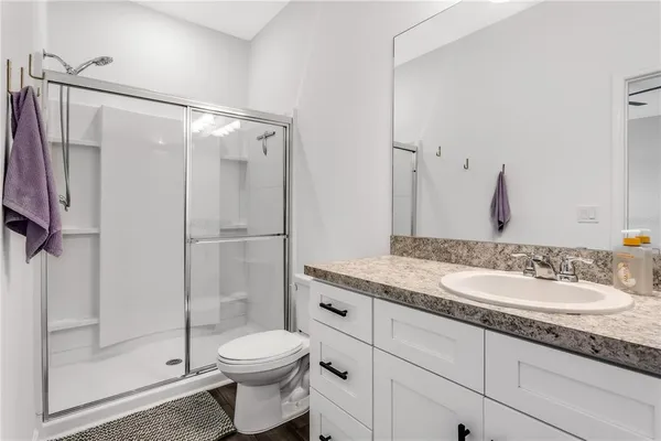 a bathroom with a granite countertop sink toilet and shower