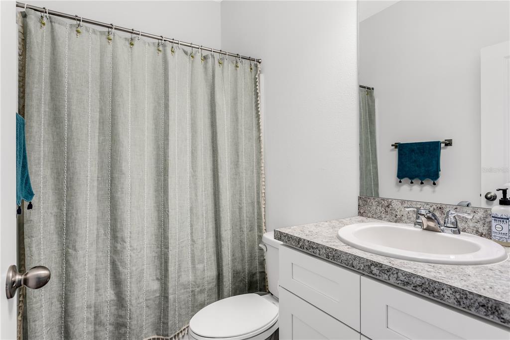 10459 Ladybug Cove Parrish, FL 34219 - Photo 24 of 36 a bathroom with a granite countertop sink and a mirror
