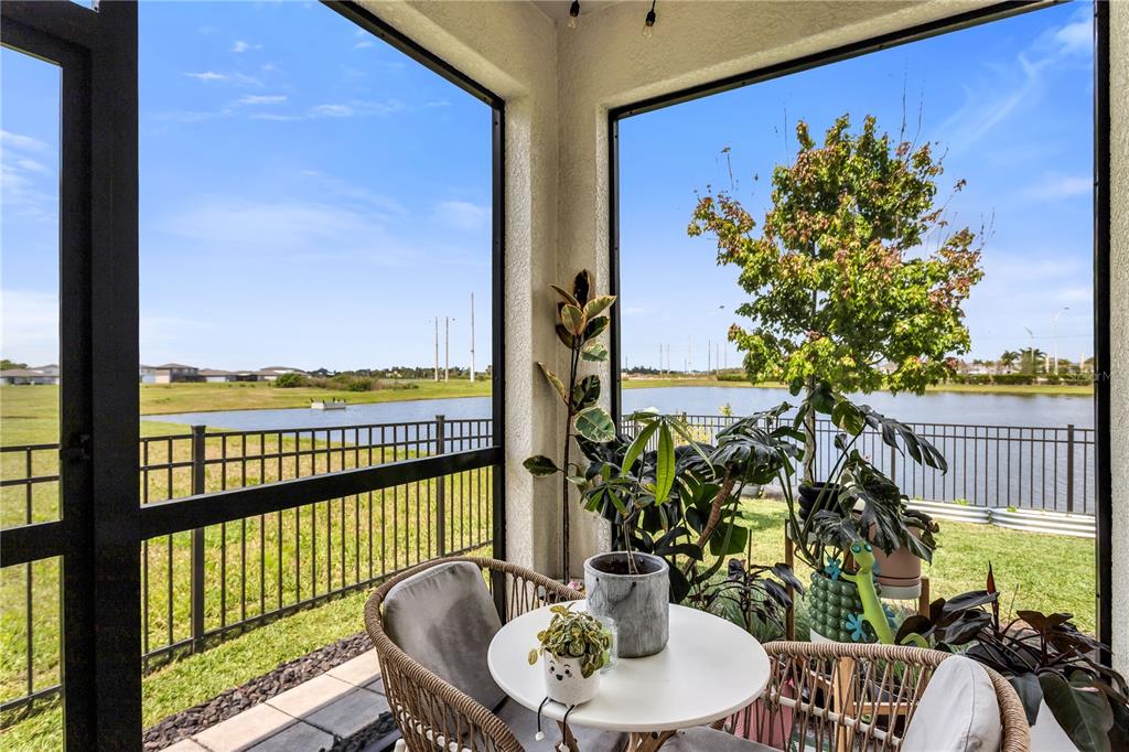 10459 Ladybug Cove Parrish, FL 34219 - Photo 28 of 36 a balcony with wooden floor table and chairs