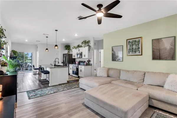 a living room with furniture and a view of kitchen
