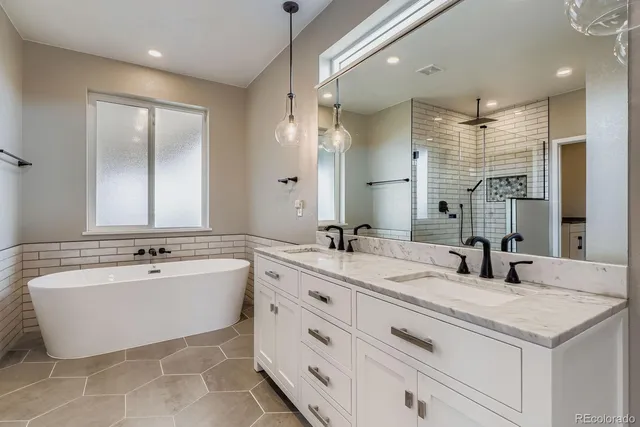 a bathroom with a double vanity sink mirror and bathtub