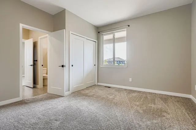 an empty room with windows and closet