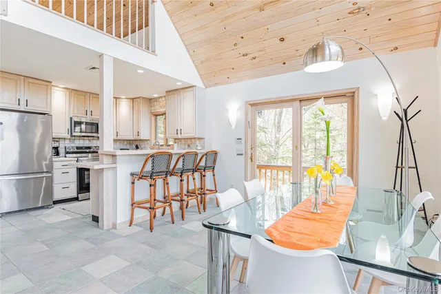 a kitchen with stainless steel appliances kitchen island granite countertop a table chairs and a refrigerator