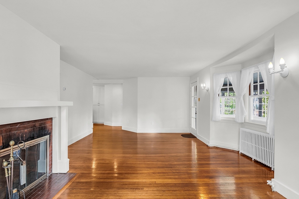42 Locust Street Marblehead, MA 01945 - Photo 13 of 42 a view of empty room with wooden floor and fireplace