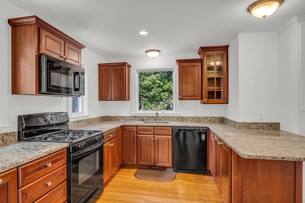 42 Locust Street Marblehead, MA 01945 - Photo 16 of 42 a kitchen with stainless steel appliances granite countertop a stove a sink and a microwave