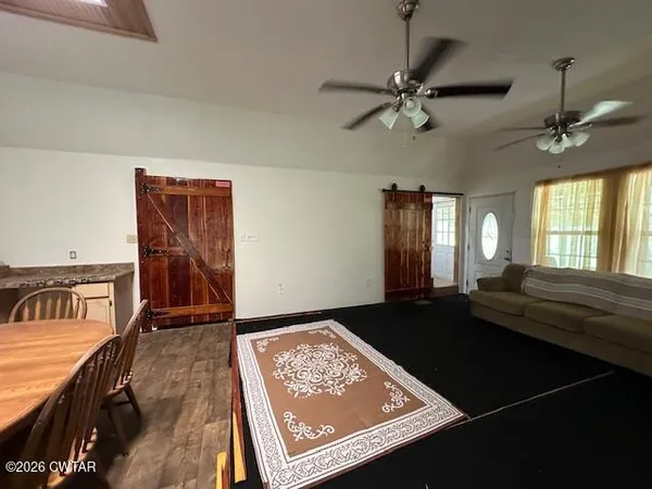 a kitchen with stainless steel appliances wooden floor dining table and chairs