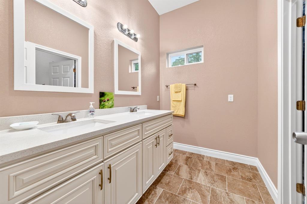 5230 Esquire Estates Road Mabank, TX 75156 - Photo 29 of 39 Double vanity with a light countertop, dual undermount sinks, and brushed nickel fixtures