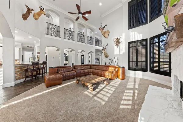 a living room with furniture kitchen view and a chandelier