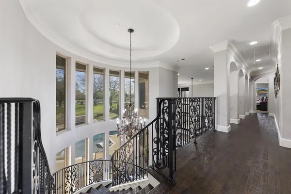 a view of a hallway with wooden floor and windows