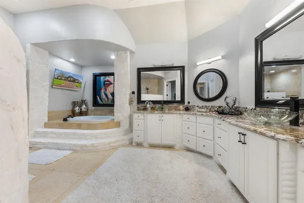 a spacious bathroom with a granite countertop sink mirror and vanity