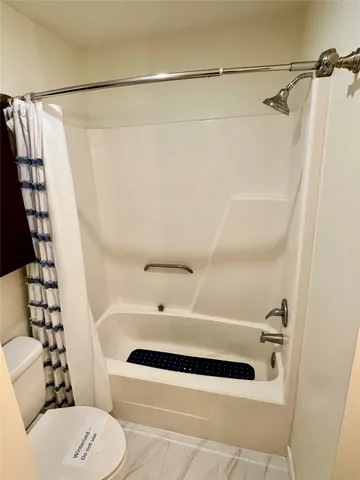 a bathroom with a shower a toilet and a shower