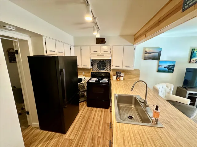 a kitchen with a refrigerator a stove top oven a sink and dishwasher