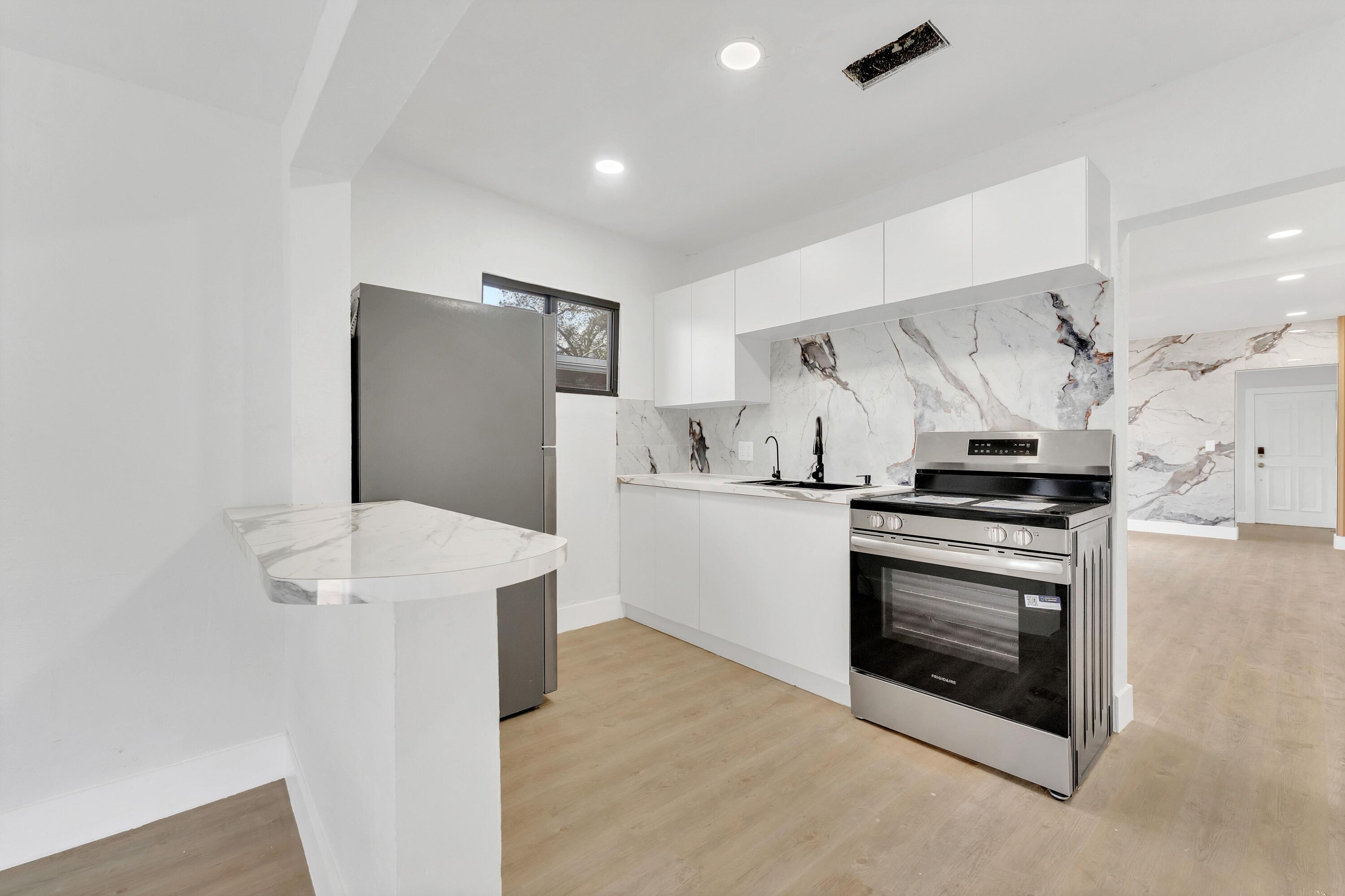 2428 Northwest 28th Street Miami, FL 33142 - Photo 6 of 19 a kitchen with stainless steel appliances a stove a microwave and a refrigerator