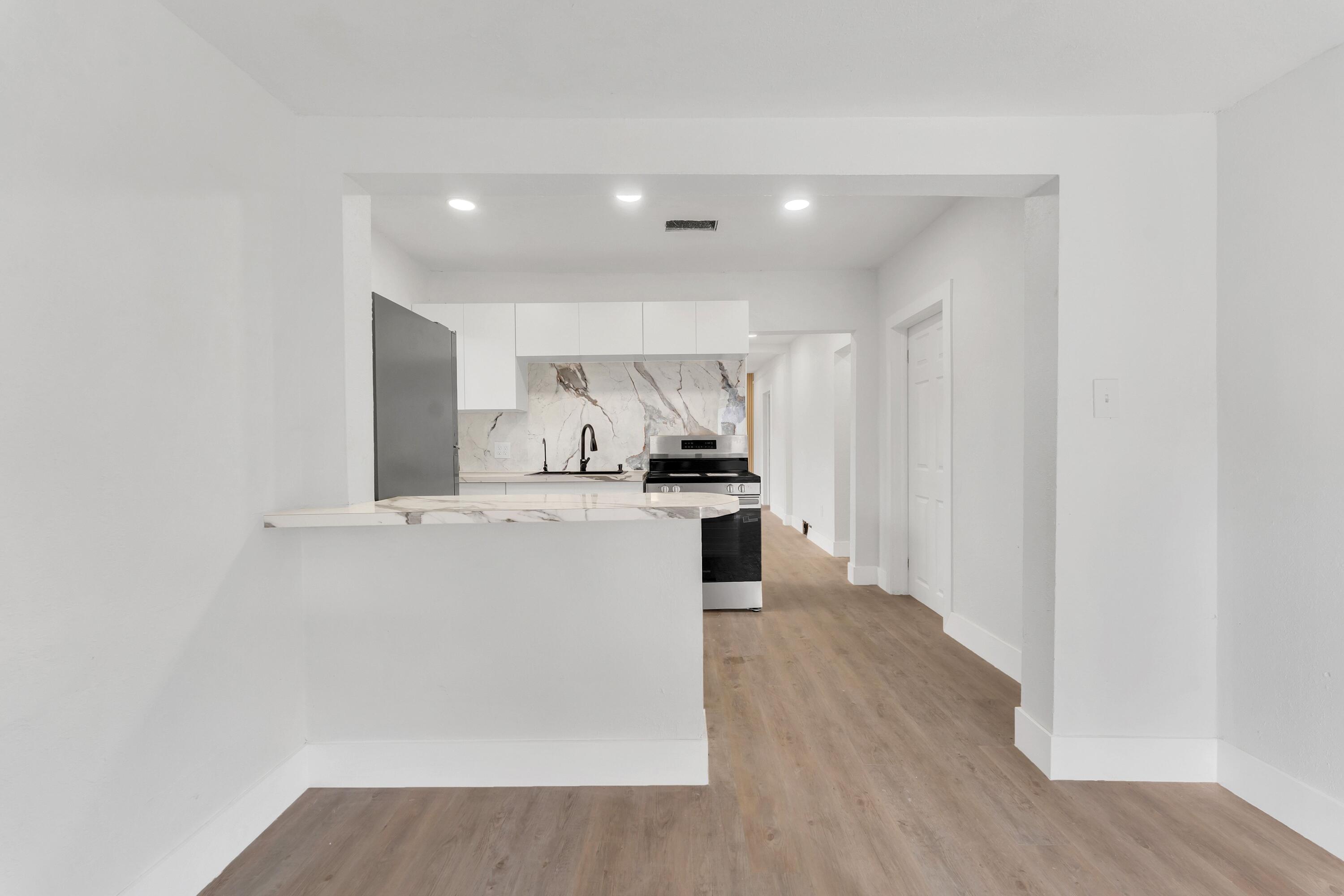 2428 Northwest 28th Street Miami, FL 33142 - Photo 7 of 19 a kitchen with a refrigerator and white cabinets
