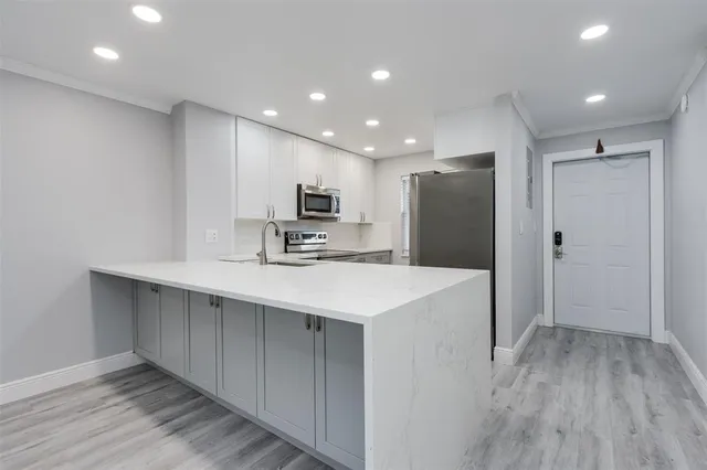 a kitchen with kitchen island a sink appliances and cabinets