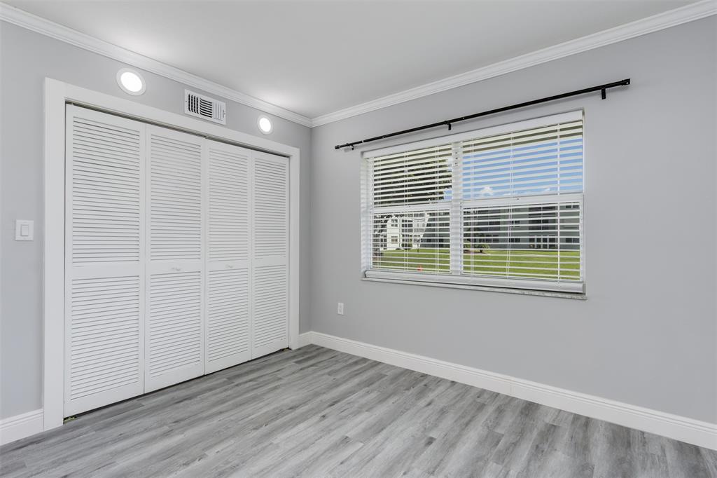 9856 Marina Boulevard, Unit 1314 Boca Raton, FL 33428 - Photo 28 of 43 a view of an empty room with wooden floor and a window