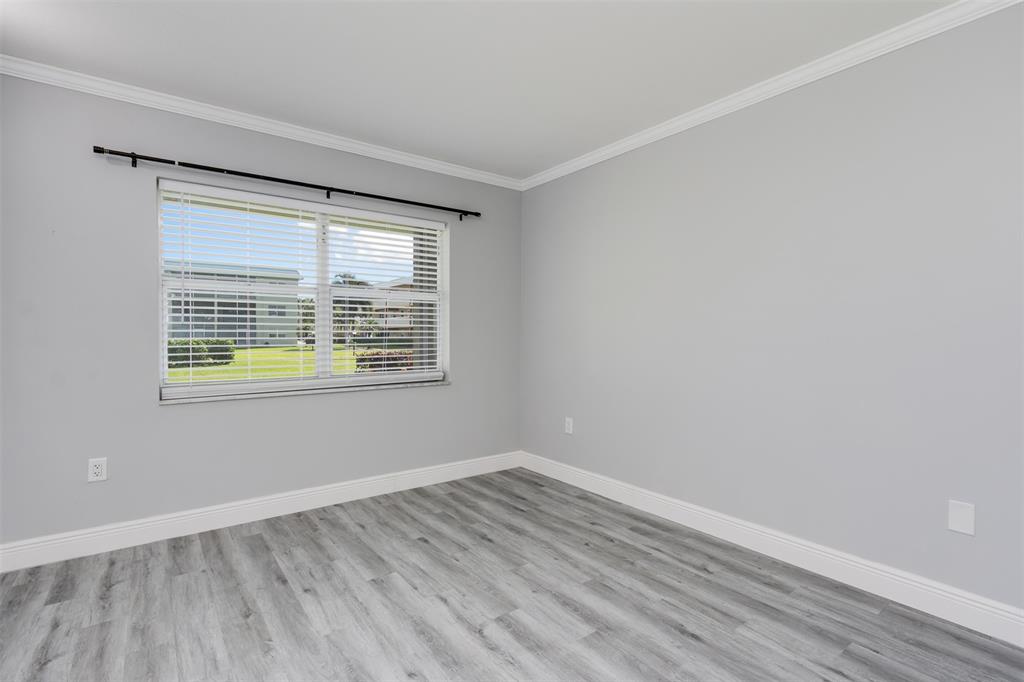 9856 Marina Boulevard, Unit 1314 Boca Raton, FL 33428 - Photo 30 of 43 a view of an empty room with wooden floor and a window
