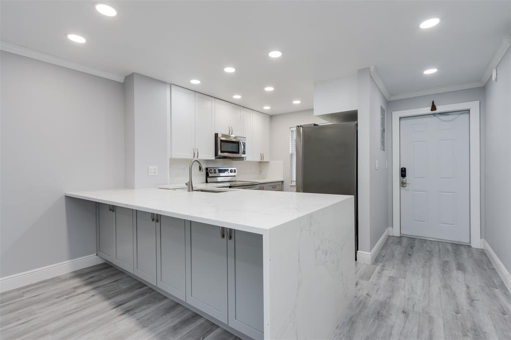 9856 Marina Boulevard, Unit 1314 Boca Raton, FL 33428 - Photo 7 of 43 a kitchen with kitchen island a sink appliances and cabinets