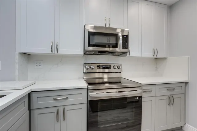 a kitchen with white cabinets and stainless steel appliances