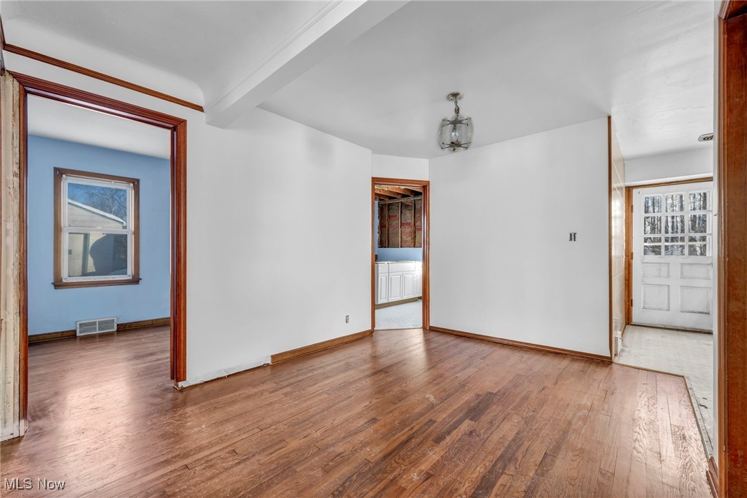 14750 Schreiber Road Maple Heights, OH 44137 - Photo 12 of 44 Spare room with beam ceiling, wood-type flooring, and hanging lights