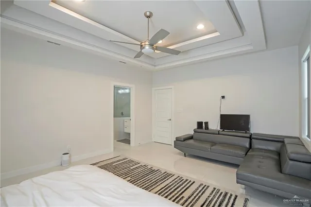 a spacious bedroom with a bed and ceiling fan
