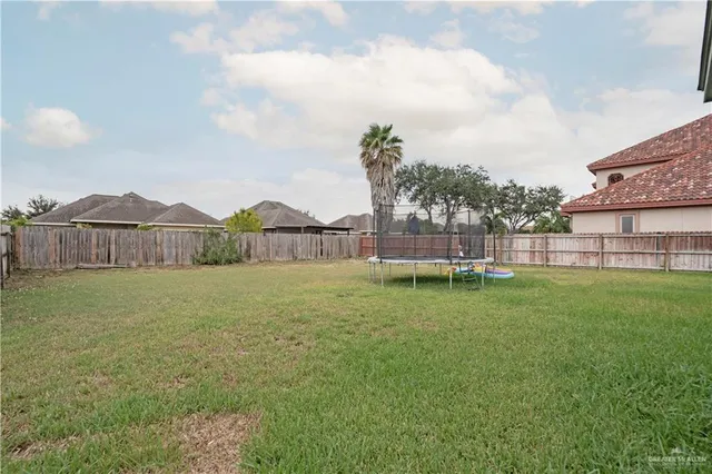 a view of a house with backyard and trampoline