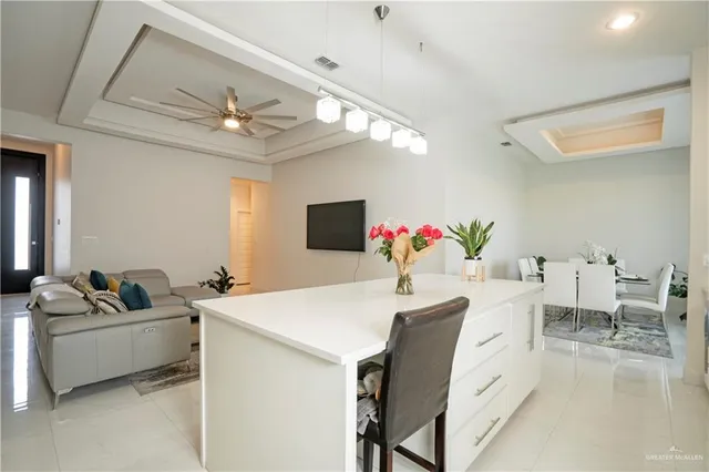 a view of a dining room with furniture and a chandelier fan