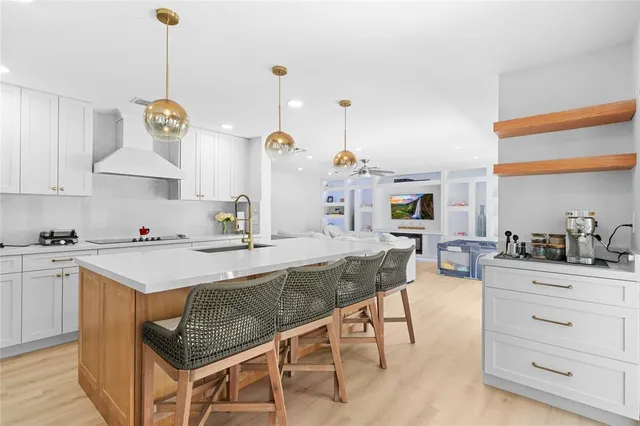 a kitchen with granite countertop a sink a stove and cabinets