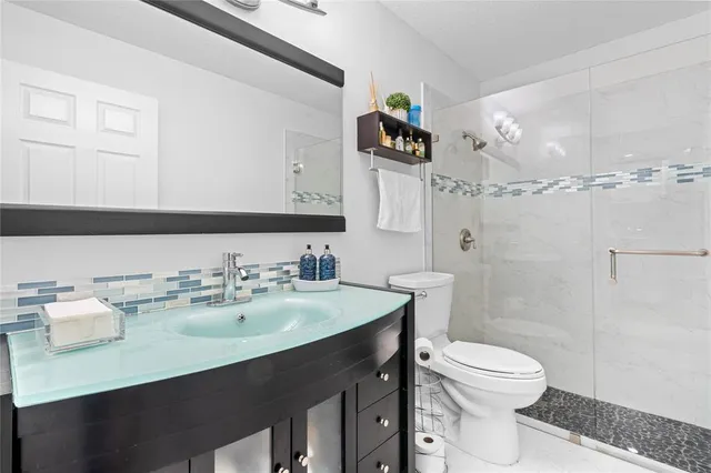 a bathroom with a sink mirror vanity and toilet