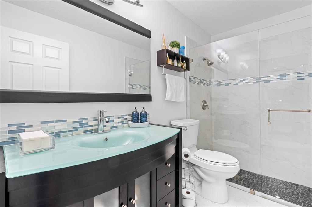 14908 Southwest 143rd Place Miami, FL 33186 - Photo 24 of 45 a bathroom with a sink mirror vanity and toilet