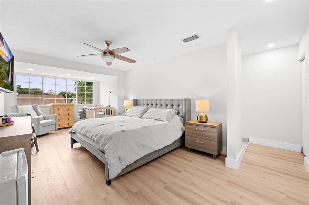 14908 Southwest 143rd Place Miami, FL 33186 - Photo 26 of 45 a spacious bedroom with a bed couch and a window