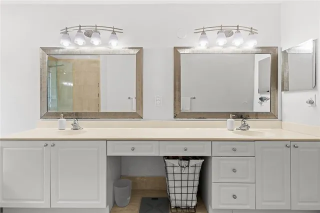 a bathroom with double vanity sinks and a mirror