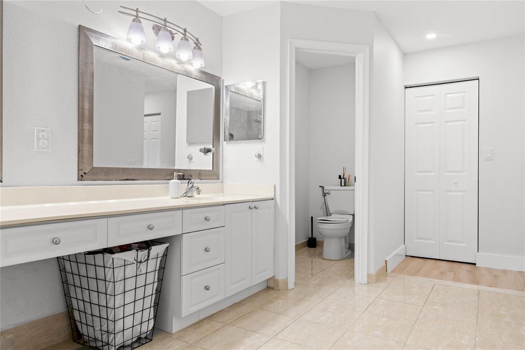 14908 Southwest 143rd Place Miami, FL 33186 - Photo 32 of 45 a spacious bathroom with a double vanity sink a toilet and a mirror