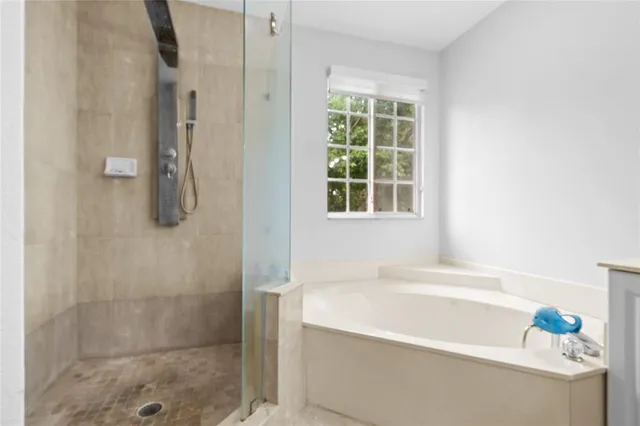 a white bath tub sitting next to a shower